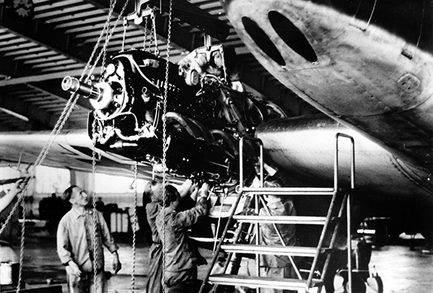 Рабочие у истребителя на заводе по производству вооружения для самолетов в фашистской Германии