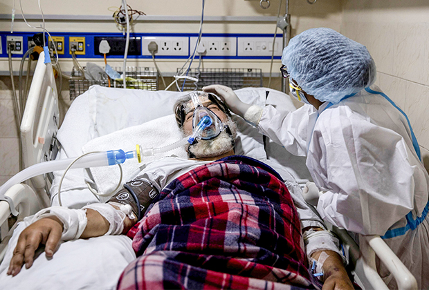 Медик ухаживает за больным COVID-19 в Нью-Дели