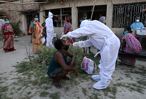 Врач берет мазок на коронавирус у деревенских жителей