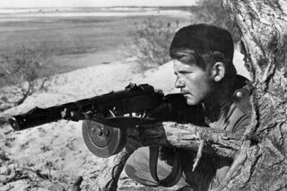 Советский разведчик И. Демченко, вооруженный пистолетом-пулеметом ППШ, на берегу Днепра. Август-сентябрь 1943 года