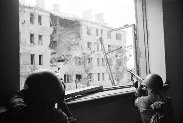 Советские солдаты, вооруженные пистолетами-пулеметами ППШ, ведут бой из окон дома. Воронеж, июль 1942 года