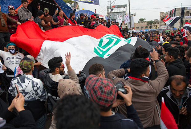 Протестующие в Багдаде несут флаг Ирака, январь 2020 года