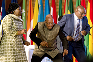 Президент ЮАР Джейкоб Зума (в центре) и премьер-министр провинции Гаутенга Дэвид Махура (справа) танцуют во время празднования Дня Африки 24 мая 2015 года в Претории