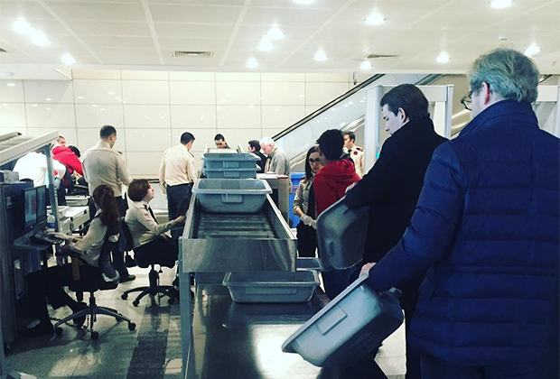 Курц проходит таможенный досмотр в аэропорту вместе с другими пассажирами