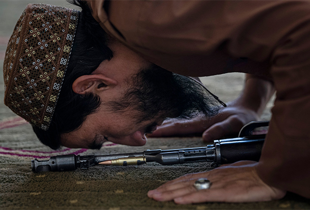 Боец «Талибана» совершает пятничный намаз