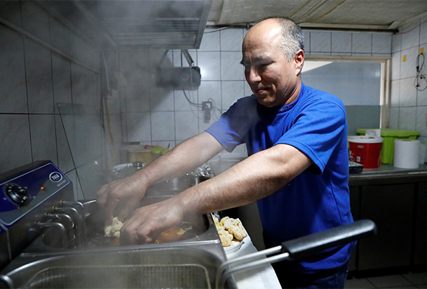 Афганский беженец работает в ресторане в Венгрии