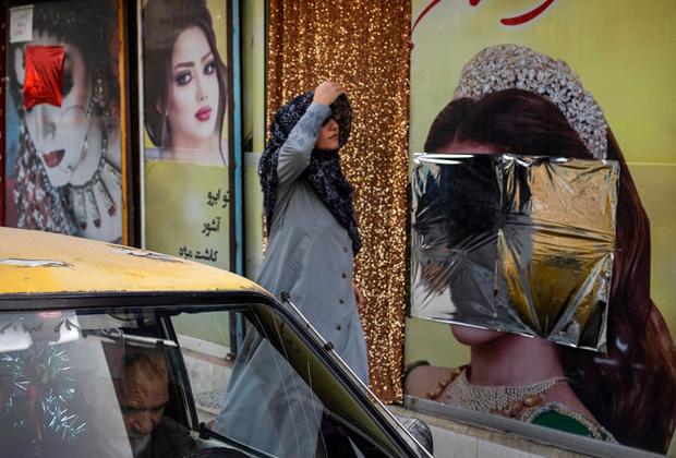 Женщина проходит мимо салона красоты в Кабуле