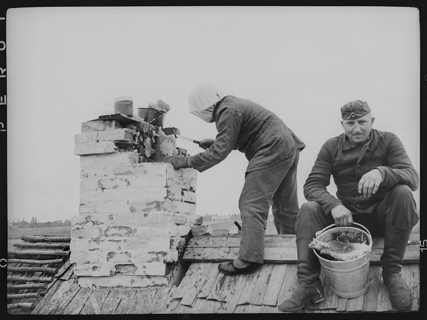 Немецкие солдаты достают соты с медом из дымохода печной трубы одного из деревенских домов. Лето 1942 года