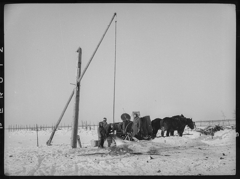 Немецкие солдаты набирают воду из деревенского колодца. Зима 1941-1942 годов