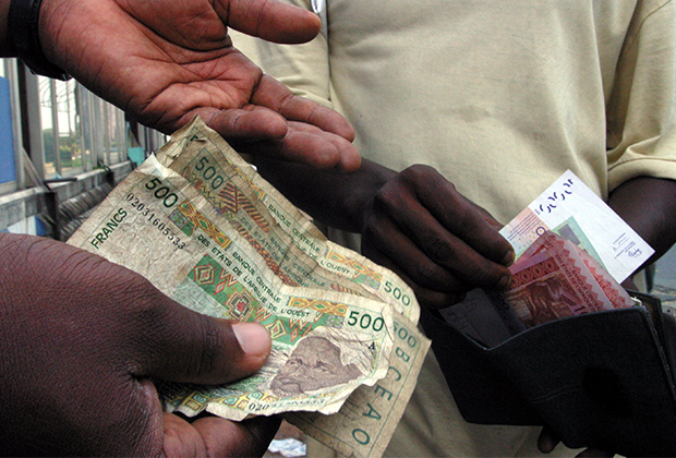 Люди обменивают деньги в Абиджане, главном мегаполисе Кот-д'Ивуара, 31 декабря 2004 года