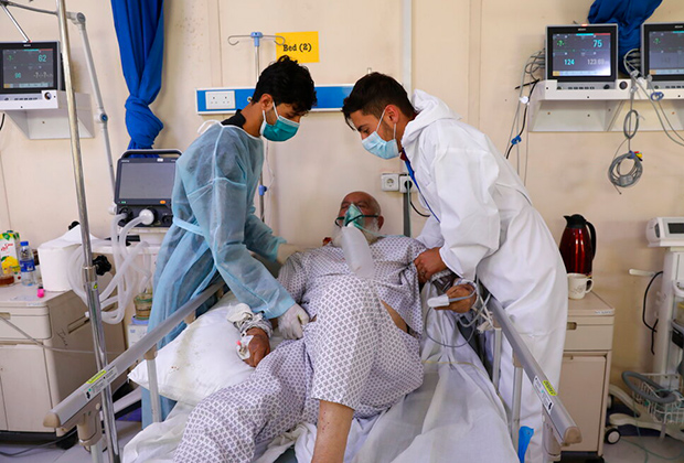 Сыновья у постели отца в афгано-японской инфекционной больнице в Кабуле, Афганистан, май 2021 года