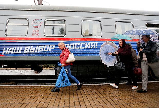 Пассажиры у поезда в городе Макеевка перед отправлением на избирательный участок в Ростовской области, где они могли проголосовать на парламентских выборах в России, 19 сентября 2021 года