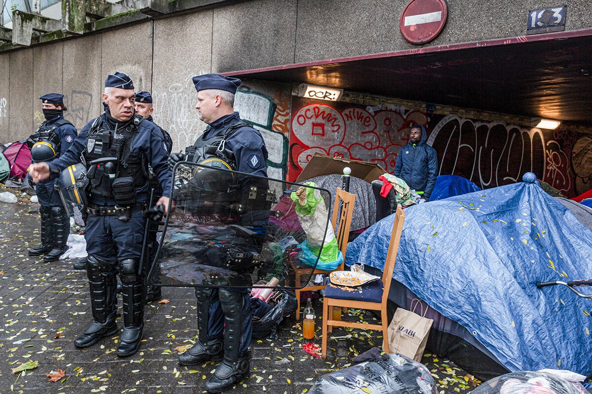 Полицейские во время акции протеста в знак солидарности с жителями временного лагеря для мигрантов под автомагистралью, где живут около 150 человек, 28 ноября 2021 года, Париж