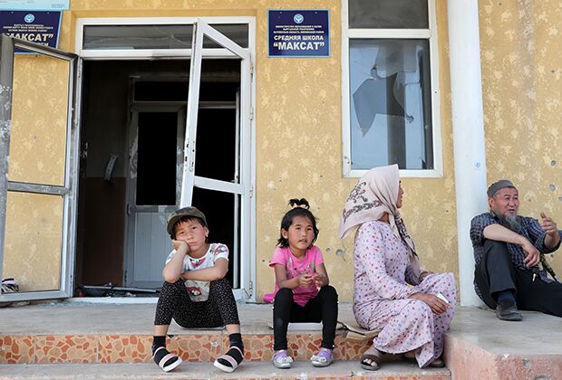 Местные жители с детьми у поврежденного здания школы в приграничном с Таджикистаном селе Максат Лейлекского района Баткенской области