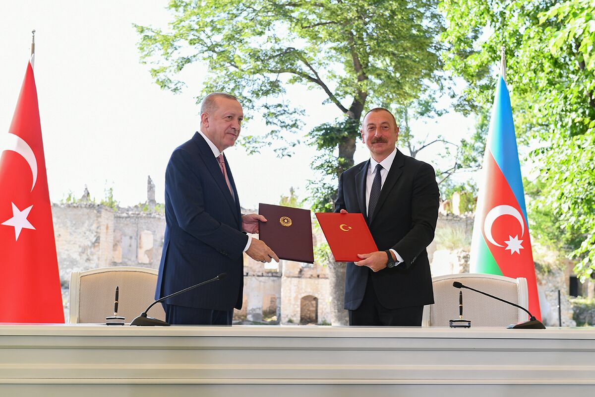 Президент Турции Реджеп Тайип Эрдоган (слева) и президент Азербайджана Ильхам Алиев (справа) подписывают декларацию о союзнических соглашениях во время встречи в Шуше, 15 июня 2021 года