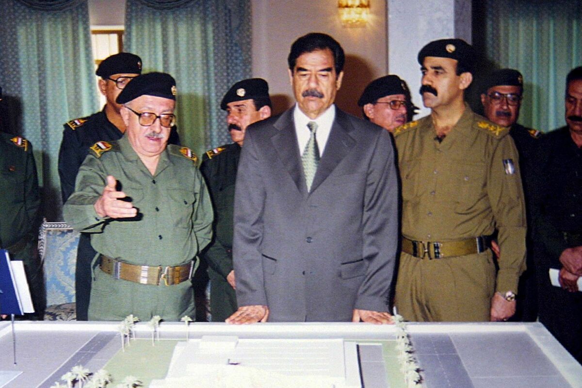 Саддам Хусейн рядом с моделью мемориала в честь погибших в ходе войны в Персидском заливе, 3 сентября 2001 года