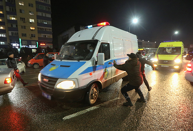 Протестующие нападают на полицейский микроавтобус в Алма-Ате. Фото: Pavel Mikheyev / Reuters