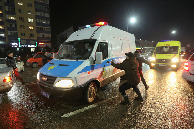 Протестующие в Алма-Ате атакуют полицейскую машину, 4 января 2022 года. Фото: Павел Михеев / Reuters