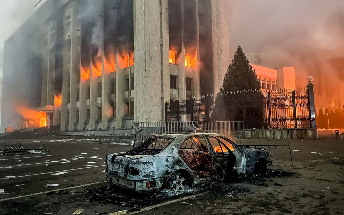 Сгоревший автомобиль возле горящего здания мэрии (акимат) Алма-Аты