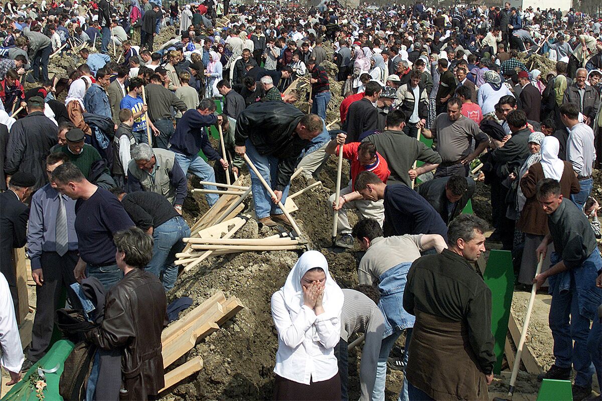 Родственники убитых во время резни в Сребренице в 1995 году хоронят останки своих близких в городском поле, 31 марта 2003 года