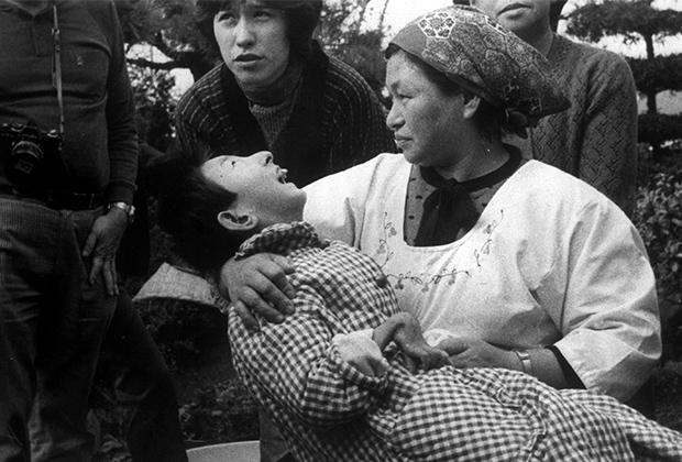 Женщина держит на руках жертву отравления в Минамате, Япония, 1973 год