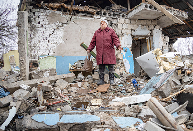 Жительница села Невельское Людмила Момот на развалинах своего дома, в который попал минометный снаряд, 10 декабря 2021 года