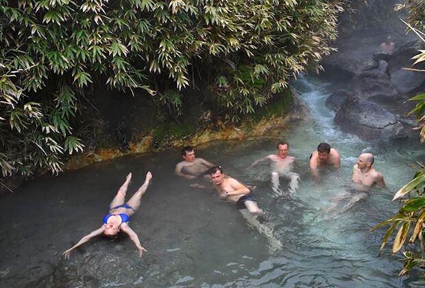 Жанровая фотография. Туристы во время купания в целебном радоновом источнике на острове Итуруп.