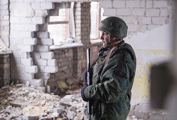 Военнослужащий ЛНР осматривает разрушенную школу в поселке Молодежный, находящемся на линии боевого соприкосновения в Луганской области.
