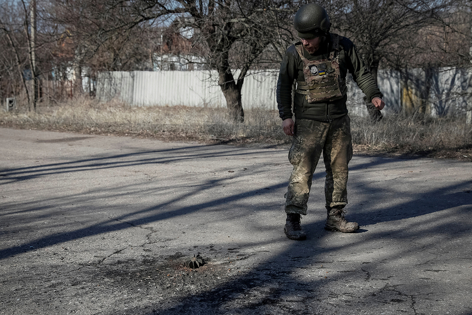 Украинский военнослужащий возле осколков 120-милиметрового минометного снаряда после обстрела у линии фронта в селе Травневое в Донецкой области, 21 февраля 2022 года