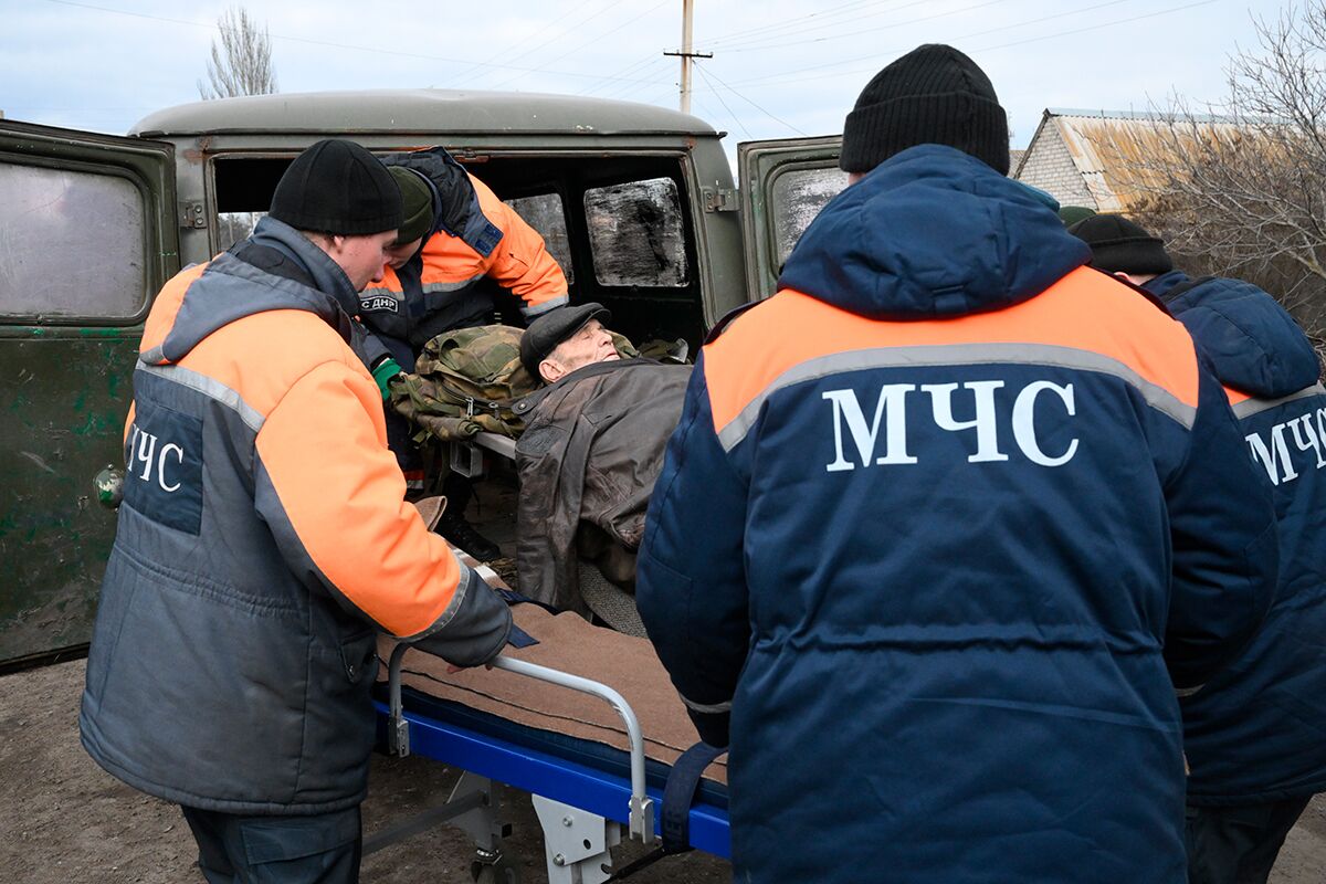 Сотрудники МЧС переносят пожилого человека в санитарную машину в Безыменном