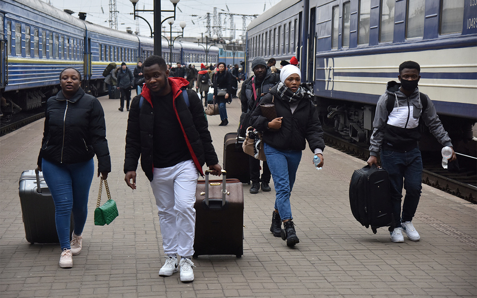 Пассажиры, в том числе эвакуированные из Сум и Киева, идут по перрону железнодорожного вокзала во Львове, 25 февраля 2022 года