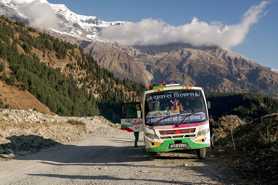 Рейсовый непальский автобус на фоне горных вершин