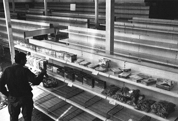 Одинокий покупатель осматривает почти пустые полки в продуктовом магазине, 19 сентября 1992 года