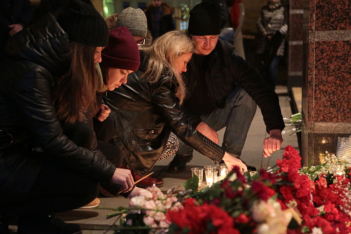 Жители Санкт-Петербурга зажигают свечи у входа в вестибюль станции метро «Спасская» в память о погибших в результате теракта