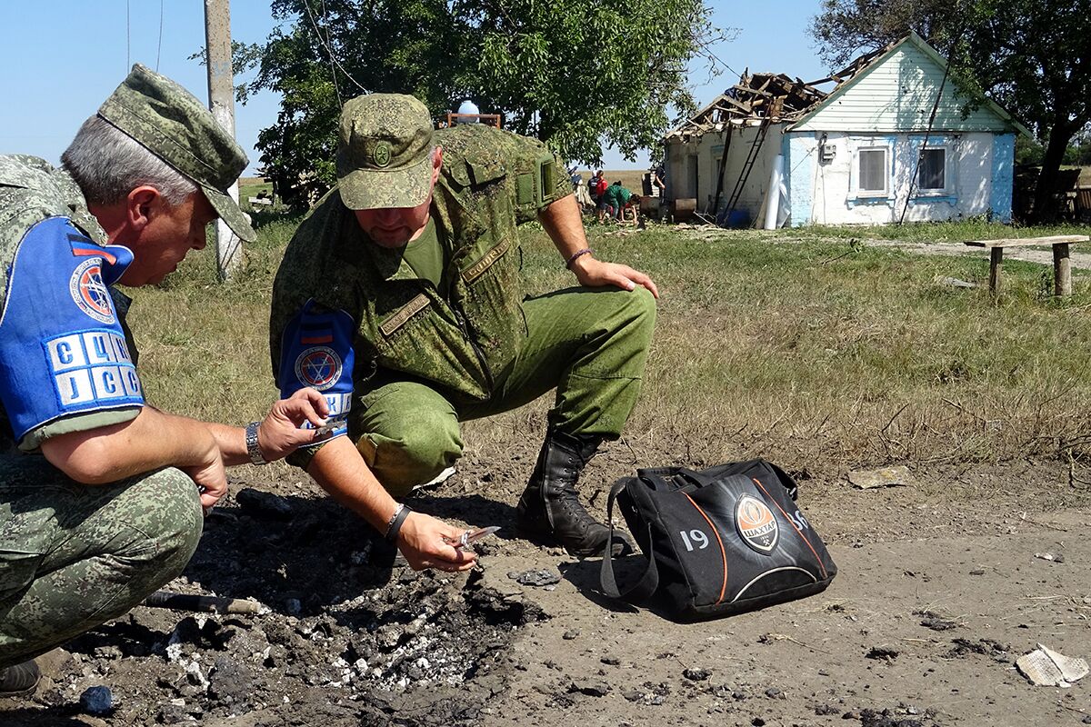 Офицеры Совместного центра контроля и координации (СЦКК) фиксируют разрушения в результате артобстрела села Октябрь Донецкой области, 2015 год 