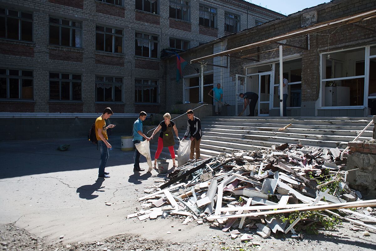 Жители Горловки убирают территорию школы № 16, пострадавшей от ночного обстрела города украинскими силовиками, 2015 год