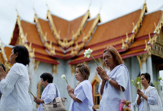 People pray as they walk around the Marble Temple or Wat Benchamabophit during the Buddhist celebration of Vesak in Bangkok, Thailand 