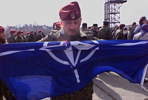 Польский солдат держит флаг НАТО