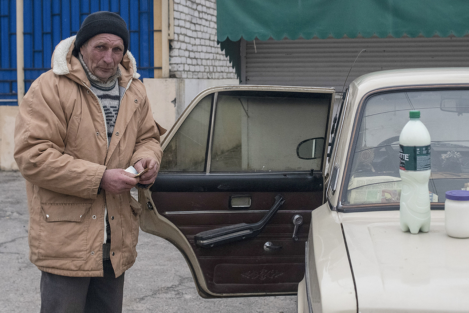 Мужчина продает молоко на одной из улиц в городе Счастье 