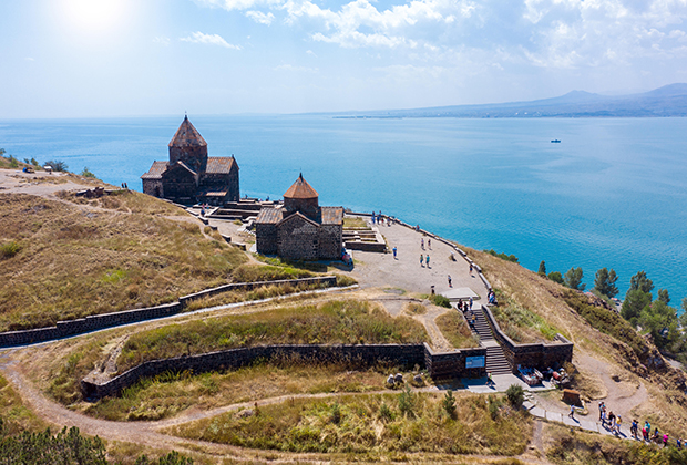 Старый монастырь на фоне озера Севан в Армении
