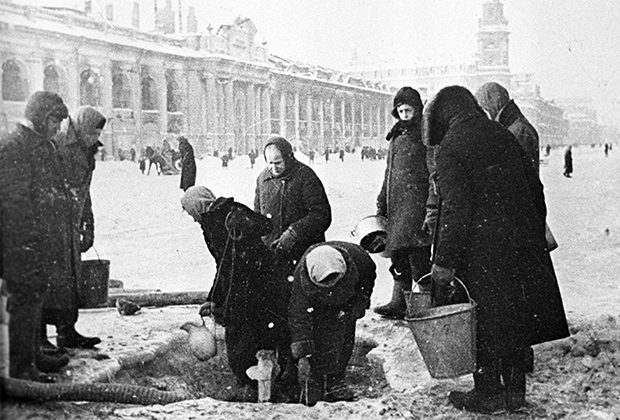 Жители блокадного Ленинграда набирают воду, появившуюся после артобстрела в пробоинах на Невском проспекте. Фото: Владимир Целик / РИА Новости