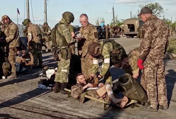 Российские военные досматривают сдавшихся в плен украинских бойцов