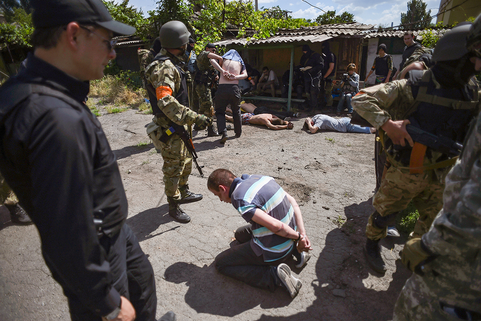 Бойцы батальона «Азов» задерживают мужчин на месте столкновения с ополченцами в Мариуполе, 13 июня 2014 года