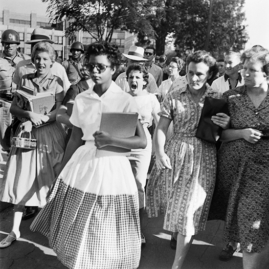Элизабет Экфорд, одна из Девятки Литл-Рока. На заднем плане — толпа белых людей и солдат Национальной гвардии, кричащих ей в след. 1957 год