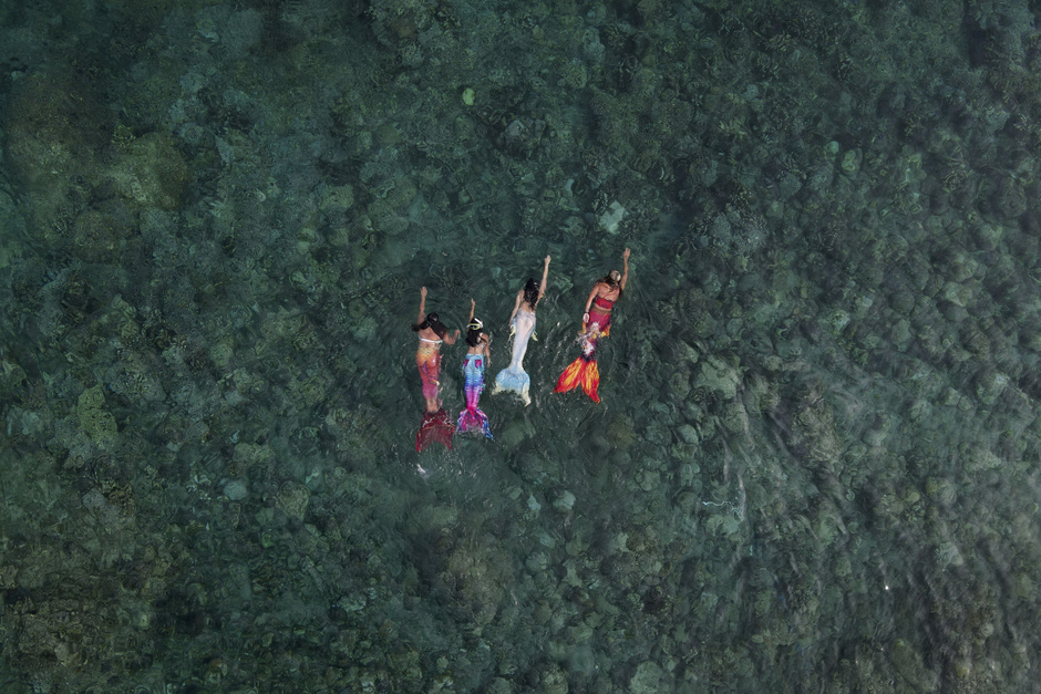 Квин Пангке Табора (крайняя справа) плавает с ученицами-русалками во время урока в Мабини. Слева направо: Шела Кандадо, Дженника Секуя и Мерил Луиза Реке. Май 2022 года