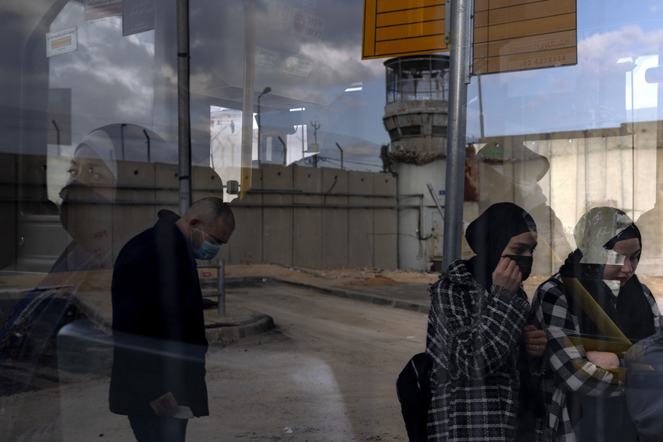 Палестинцы садятся в автобус после пересечения границы с Израилем через контрольно-пропускной пункт Каландия между городом Рамалла и Иерусалимом