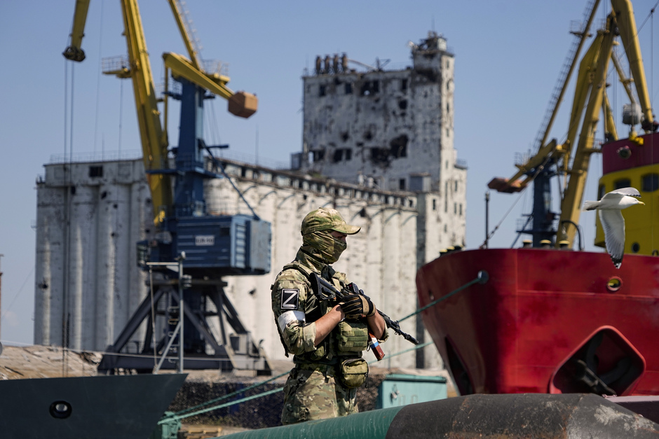 Российский солдат охраняет причал с зернохранилищем в районе Мариупольского морского порта, который недавно начал свою работу после ожесточенных боев в Мариуполе, 12 июня 2022 года