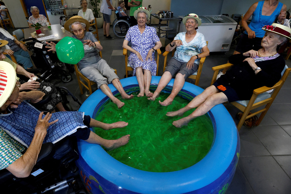 Жительницы дома престарелых окунают ноги в бассейн из-за жары в городе Гримберген, Бельгия 