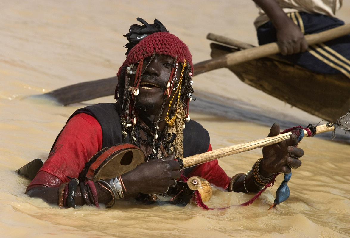 Западная Африка. Гриот развлекает гостей фестиваля рыбной ловли