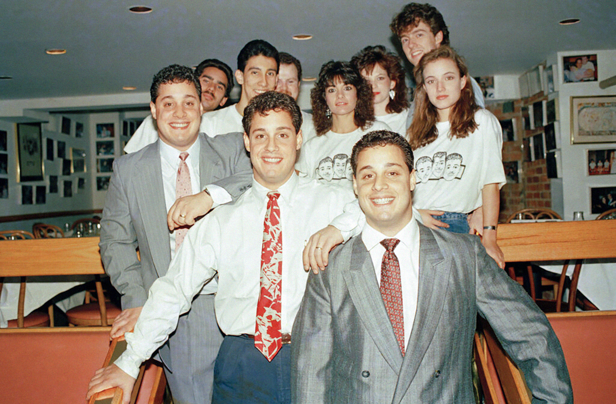 Тройняшки Роберт Шафран (слева), Дэвид Келлман (в центре) и Эдди Галланд (справа) позируют с некоторыми из сотрудников в их нью-йоркском ресторане «Тройняшки», 27 октября 1988 года